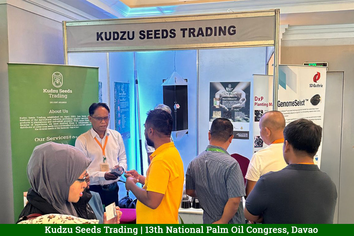 Kudzu Seeds Trading booth at the 13th National Palm Oil Congress in Davao, with visitors at the counter, an RB Lure trap and a SoilBoost EA poster